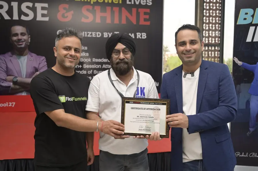 Jasminder holding a framed workshop certificate